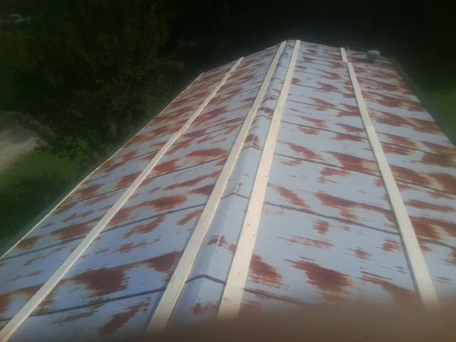 Rusted metal roof panels with new wood purlins before replacement — Storm Damage Roof Repair in Cold Spring Harbor by Roofing Brothers